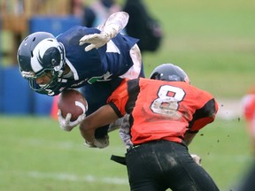 Clarke Road Trojans safety Tazie Vang Bell upends Dante Nicholls of the Rams during their TVRA Central senior football game at Laurier on Thursday. Nicholls scored the opening touchdown and the Rams went on to win 27-8 to earn a place in the A playoffs, while the Trojans head to the B playoffs. (MIKE HENSEN, The London Free Press)