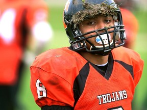 Clarke Road running back Tazie Vang Bell, fatigued after playing both ways as safety and runningback, shows the turf on his helmet after he was tackled after his best run of the game leaving helmet sized gouge in the Laurier turf during their game at Laurier on Thursday November 2, 2017. With first place out of reach with the South Lions, the battle for second place between the Rams and the Trojans was much anticipated. The Rams scored early, and ran out a 13-0 halftime lead, before leading 27-0 when Clarke Road was able to get on the boards with a Bell touchdown and a two point conversion. The game ended 27-8. (MIKE HENSEN, The London Free Press)