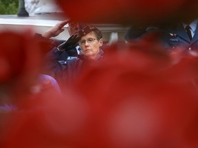 Pat hope of 418 Wing Royal Canadian Air Force Association (RCAFA) is seen through a field of ceramic poppies as she salutes during a singing of O Canada during a poppy dedication ceremony at Eastminster United Church on Saturday November 4, 2017 in Belleville, Ont. Tim Miller/Belleville Intelligencer/Postmedia Network