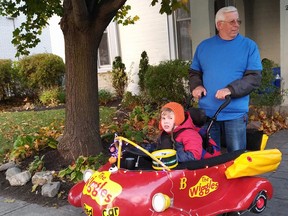 Submitted Photo
Six-year-old Brady Wilson, along with his grandfather Jim Wilson, get ready to go out trick or treating on Halloween night. Brady's costume, a replica of The Big Red Car from TV show The Wiggles, was designed and built by a group of Loyalist students as part of the Magic Wheelchair project.