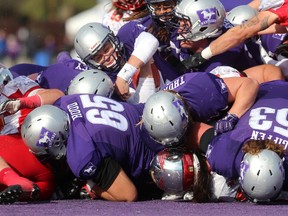 Behind a dominant offensive line Chris Merchant scores on a quarterback sneak during an absolutely dominating performance by the Western Mustangs over the Guelph Gryphons in their semifinal at TD stadium on Saturday November 4, 2017. Winning 66-12, after gifting the Gryphons with 9 of those points on a fumble and a safety, the Western defence shut down the Gryphons offensively while the Mustang running backs were running freely into the Gryphon secondary. Mike Hensen/The London Free Press/Postmedia Network