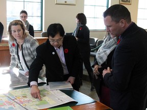 Stony Plain Mayor William Choy (centre) shows Economic Development Minister Deron Bilous (right) a map of the redevelopment area which will be the beneficiary of a $40,000 grant during an announcement in Stony Plain on Nov. 6.