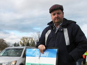 Mark Russell stands at the London Road entrance to Lambton College Monday where, he said, a motorist struck him. Russell, a computer studies professor, is one of thousands of striking college workers in the province. (Tyler Kula/Sarnia Observer/Postmedia Network)