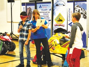 Pictured above are two students from HW Pickup School assisting Lori Zacaruk with a safety presentation that discusses how a person’s life, and their family’s would change is they were to become blind or paralyzed after an accident involving a quad or a snowmobile.