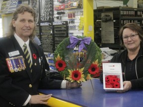 Marlene Kellier-Pinchbeck, first vice president of the Royal Canadian Legion Branch #44 Whitecourt, drops off a poppy box with Susan King, owner of the local Napa Auto Parts on Oct. 31 (Joseph Quigley | Whitecourt Star).