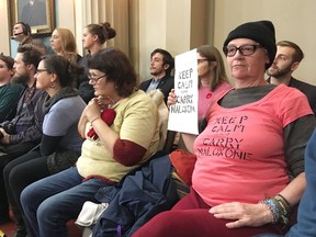 Dozens of people, many carrying signs and wearing shirts saying “Keep calm and carry naloxone.” came out to Kingston city council to support a naloxone distribution plan in Kingston on Tuesday. (Elliot Ferguson/The Whig-Standard)