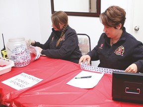 Champion Fire Department members Becky Muilwijk, left, and Catherine Pooley sell 50/50 tickets Saturday during the department’s annual roast and auction fundraiser held at the Champion Community Hall. Jasmine O’Halloran Vulcan Advocate