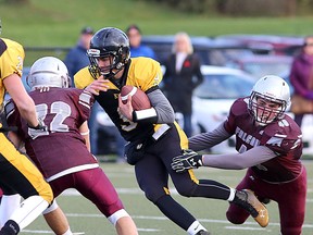 La Salle Black Knights quarterback Nigel LeGood runs for yardage as Frontenac Falcons' Leslie Silas and Keenan Bedard defend during their Kingston Area Secondary School Athletic Association senior boys football semifinal at Miklas-McCarney field on Tuesday. (Ian MacAlpine/The Whig-Standard)