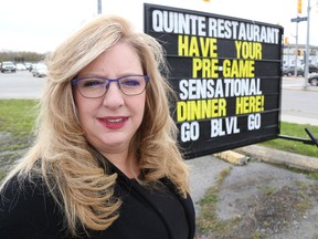 Jason Miller/The Intelligencer 
City restaurateur Kelly McCaw, also a city councillor, stands next to a sign with the words Go Belleville Go replacing the Go Sens Go wording originally used, after the Belleville Senators asked her to remove its name from the advertisement.