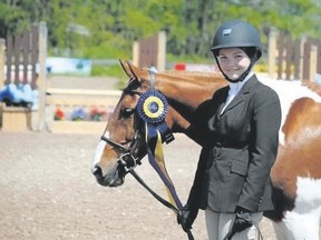 Nicole Cullen poses with Mud Slide and one of the many ribbons he?s won in show jumping since her family bought the pony in 2006.