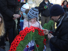 Residents pin their poppies to the People's Wreath at end of the City of Kingston Remembrance Day Civic Ceremony at the Cross of Sacrifice in Kingston, Ont. on Saturday November 11, 2017. Steph Crosier/Kingston Whig-Standard/Postmedia Network