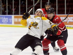 Sarnia Sting's Adam Ruzicka (21) is hauled down by Owen Sound Attack's Jacob Friend (2) in the first period at Progressive Auto Sales Arena in Sarnia, Ont., on Sunday, Nov. 12, 2017. (Mark Malone/Chatham Daily News/Postmedia Network)