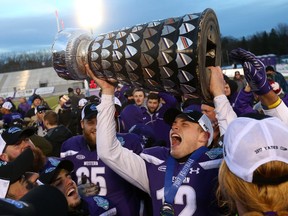 Western Mustangs quarterback Chris Merchant holds the Yates Cup after the Mustangs defeated the Laurier Golden Hawks 75-32 Saturday at TD Stadium.  (MIKE HENSEN, The London Free Press)