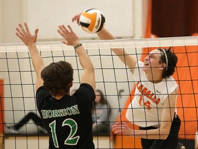 Tyrus Cuculick, right, of Lasalle Lancers, attempts to spike the ball past Jacob Lamontagne, of Horizon Aigles, during senior boys volleyball final action at Lasalle Secondary School in Sudbury, Ont. on Saturday November 11, 2017. John Lappa/Sudbury Star/Postmedia Network