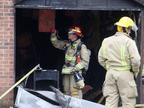 Kingston firefighters look at the damage done by a fire in a garage on Wright Crescent in Kingston, Ont. on Tuesday, Nov. 14, 2017. 
Elliot Ferguson/The Whig-Standard/Postmedia Network