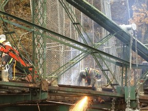 Workers use cutting torches as they prepare Blackfriars bridge for transport next late next week. The iconic bridge will be restored off site and then returned to its location in London. (MIKE HENSEN, The London Free Press)