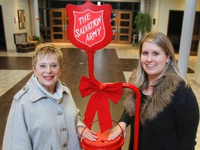 Salvation Army volunteer Carol Roche, left, and Christmas Kettle co-ordinator Maria Sadowy pose with one of the 19 Christmas Kettles on Tuesday at the Salvation Army Citadel in Kingston. The annual campaign launch is starting this Friday at the Cataraqui Centre and organizers are hoping to raise $310,000 for the variety of local programs and services throughout the year. (Julia McKay/The Whig-Standard)
