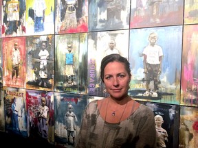 Heather Haynes and her 80 portraits of Congolese orphans on the Wall of Courage at the Firehall Theatre in Gananoque. (Photo by Jeff Montgomery/Submitted Photo)