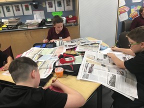 St. Charles College students Brady Brown, Ruby Doyle and Jack Gouchie read newspapers in a Grade 7 literacy class. Supplied photo
