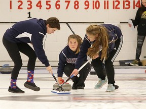 Marymount Academy skip Bella Croisier keeps her eye on the rock as teammates Sidney Musicco and Grace Woodliffe sweep during high school curling season opening-game action against the Lively Hawks in Sudbury, Ont. on Tuesday, November 14, 2017. Gino Donato/Sudbury Star/Postmedia Network