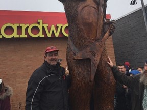 Tree carver Robbin Wenzoski stands  by his latest creation the EOA Sasquatch on Hamilton Road. (HANK DANISZEWSKI, The London Free Press)