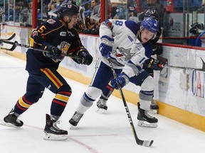 Macauley Carson, right, of the Sudbury Wolves, and Jaden Peca, of the Barrie Colts, battle for the puck during OHL action at the Sudbury Community Arena in Sudbury, Ont. on Friday November 10, 2017. John Lappa/Sudbury Star/Postmedia Network