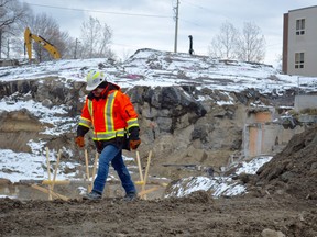 Mike Cardinal, project superintendent with Autumnwood, strolls along the edge of the work site behind Red Oak Villa on Tuesday. An opening where a tunnel once extended from the former hospital is visible behind him to the right. (Jim Moodie/Sudbury Star)