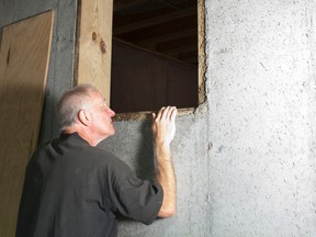 Man looking into crawl space under house. (Photo by Getty Images)