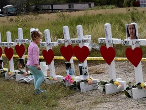 Shaelyn Gisler, 4, prepares to leave flowers on crosses named for the victims outside the First Baptist Church, which was the scene of a mass shooting that killed 26 people in Sutherland Springs, Texas, on Nov. 9. (Mark Ralston/Getty Images)