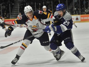 Barrie's Joey Keane tries to hold off Sudbury's Darian Pilon in a puck race on Thursday, Nov. 16, 2017. Mark Wanzel photo