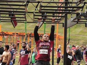 OCR athlete, Austin Perrault, tackles some monkey bars during one of a handful of obstacle course races he’s competed in this year. - Photo supplied by Austin Perrault