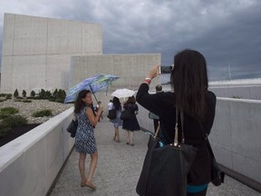 A woman stops to take a photo of the Canadian National Holocaust Monument following its official opening ceremony in Ottawa, Wednesday September 27, 2017. THE CANADIAN PRESS/Adrian Wyld