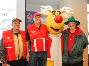 Three 20 year volunteers --William Bond, Philip Henderson and Bubs Van Hooser -- pose for a photo with long-time friend Rudy the reindeer at the launch of the 2017 Operation Red Nose Kingston campaign at the Kingston Police station in Kingston on Friday. (Julia McKay/The Whig-Standard)