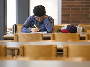 South Korea?s Seongtae Ha, who studies supply-chain management at Fanshawe College, hits the books Sunday in a school restaurant before classes resume Tuesday after a five-week strike. (Mike Hensen/The London Free Press)