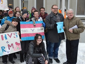 Coun. Mike Doody, right, and Matti Villeneuve, president of Fierté Timmins Pride, stand with students from the Gay-Straight Alliance at Timmins High & Vocational School after a Monday afternoon flag raising outside city hall for the transgender day of remembrance.