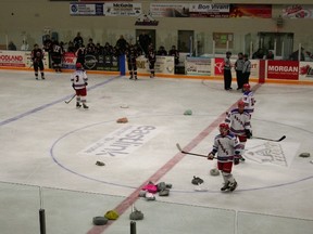 The Radars players gather pajamas thrown on the ice by the crowd after scoring their first goal. All the PJs collected from the PJ Toss will go to the Huron County Christmas Bureau.