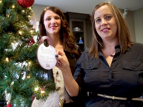 Victoria Chalmers, owner of Home Instead Senior Care (left), and Lyndsay Voisin, the organization’s quality assurance specialist, hang ornaments on a Christmas tree at Home Instead’s location on Highbury Avenue. Every Christmas, Home Instead’s Be a Santa to A Senior program offers an opportunity for Londoners to purchase Christmas gifts for seniors in need during the holidays. (CHRIS MONTANINI, Londoner)