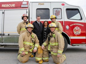 United Way of Kingston, Frontenac, Lennox and Addington president and CEO Bhavana Varma poses with Kingston Fire and Rescue Deputy Chief Neville Murphy and members of Pumper 241 on Tuesday in front of one of the new fire trucks that will be on hand for a fundraising event on Saturday featuring holiday family photos with a fire truck. (Julia McKay/The Whig-Standard)