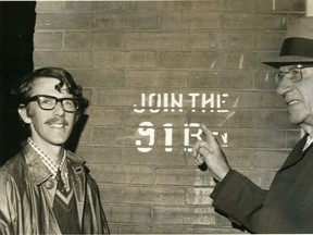 Military historian Brian Sim, left, and First World War veteran Charles Baldwin unveil restored historic recruiting slogan in 1975 in St. Thomas, painted on the wall of the Sutherland Press building. With the derelict factory's demolition, the stencil has been saved. (St. Thomas Times-Journal collection/Elgin County Archives)