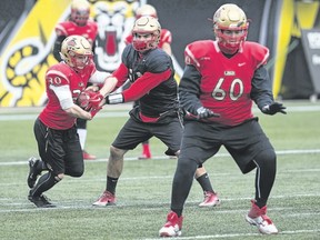 Laval Rouge et Or quarterback Hugo Richard hands off to Alexis Cote during practice Thursday in Hamilton ahead of the Vanier Cup against the Western Mustangs on Saturday at Tim Hortons Field. (The Canadian Press)