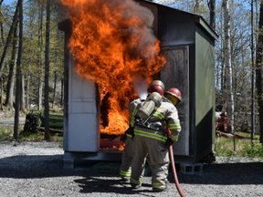Firefighters douse a deliberately set blaze in a shed at the Ontario Fire College in Gravenhurst as part of a week-long fire investigations course in May. Once it was put out, investigators-in-training examined the room to determine the fire's origin and cause. (Jennifer Bieman/The London Free Press)
