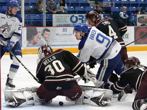 Dawson Baker, right, of the Sudbury Wolves, looks for a rebound as goalie Dylan Wells, of the Peterborough Petes, looks for the puck during OHL action at the Sudbury Community Arena in Sudbury, Ont. on Friday November 24, 2017. John Lappa/Sudbury Star/Postmedia Network