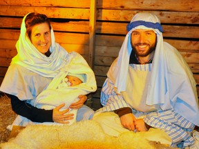 Pastor Nate and Alli Schultz portrayed Joseph and Mary during the Bethlehem Live two-night performance held on the well-decorated grounds of Upper Thames Missionary Church (UTMC) in Mitchell this past Friday and Saturday evenings, Nov. 24 and 25. They are holding daughter Casey, who was bundled in swaddling clothes as the baby Jesus for the story.  ANDY BADER/MITCHELL ADVOCATE
