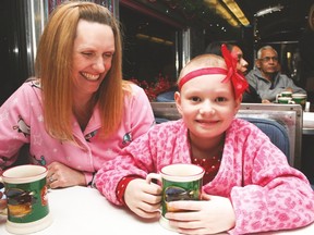 Aspen Crossing held its annual Polar Express train ride for children with cancer on Thursday. Here, Eight-year-old Grace Couldwell, from Calgary, enjoys some hot chocolate with mom Nancy. Grace is currently fighting leukemia.