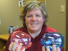 Paula McKinlay, with the Canadian Cancer Society's Sarnia-Lambton office, holds plastic piggy banks local residents are being asked to fill with donations over the holidays for the Wheels of Hope cancer patient transportation program. The fundraiser is called Pigs of Hope. (Paul Morden/Sarnia Observer/Postmedia Network)