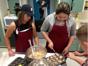 Wallaceburg District Secondary School Grade 12 students Makayla Hamm, left, and Taylor Myers prepare some food as park of the Food Works project. The project, which runs over eight weeks, has Grade 12 and Grade 8 students working together to learn about local food, cooking, and healthy eating.