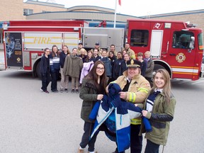 Kaitlin McMahon and Taylor Ryan, Grade 11 students at CCH, are joined by deputy fire Chief Jack Burt as well as other supporters of the annual coat drive organized by the school’s social justice club, Crusaders In Action, and the London Fire Department. (CHRIS MONTANINI, Londoner)