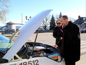 Kingston Mayor Bryan Paterson and Sheila Kidd, director of transportation services for the city look at the engine of a new electric vehicle on Wednesday November 29 the city has just purchased. Ian MacAlpine /The Whig-Standard/Postmedia Network