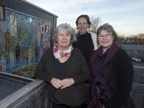 London Potters Guild members, from left, Susan Day, Beth Turnbull Morrish and Judy Sparks pose in front of the enormous mosaic they helped build on the side of the London Clay Art Centre in Old East Village. The work, made of 18,000 individual clay pieces, faces Elizabeth Street just north of Dundas Street. Its official unveiling is Thursday. (DEREK RUTTAN, The London Free Press)