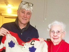 Bobby Crawford, one of Floyd Crawford's seven sons, with Frances Mulholland and the sweater worn by Floyd Crawford at the 1959 world hockey championships in Prague. (Submitted photo)